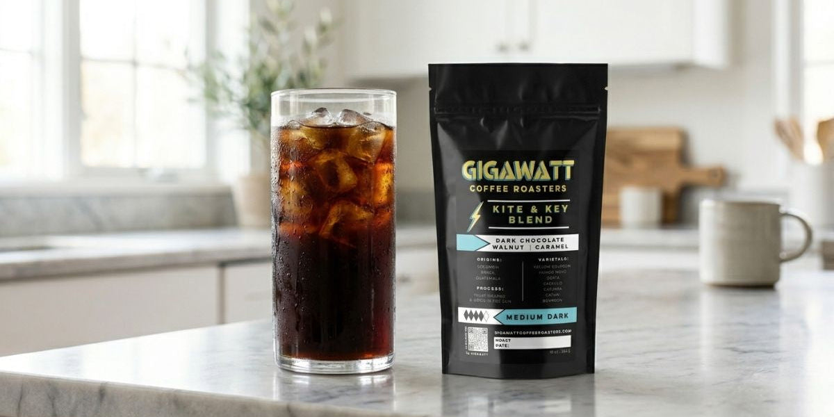Glass of cold brew coffee with ice on a kitchen counter next to a bag of Gigawatt Coffee