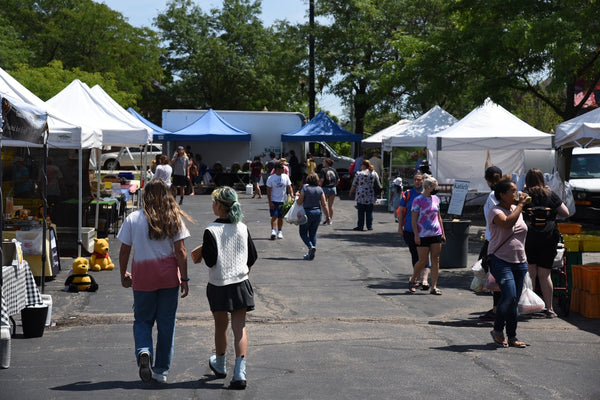 Shoppers browsing vendor booths at the Schaumburg Farmers Market at Trickster Cultural Center on a Friday morning