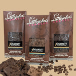 Coffee Chocolate Bar Collection 3-bar variety pack by Gigawatt Coffee Roasters and Littlejohn's Candies on a solid light brown background with chocolate and coffee beans on the surface