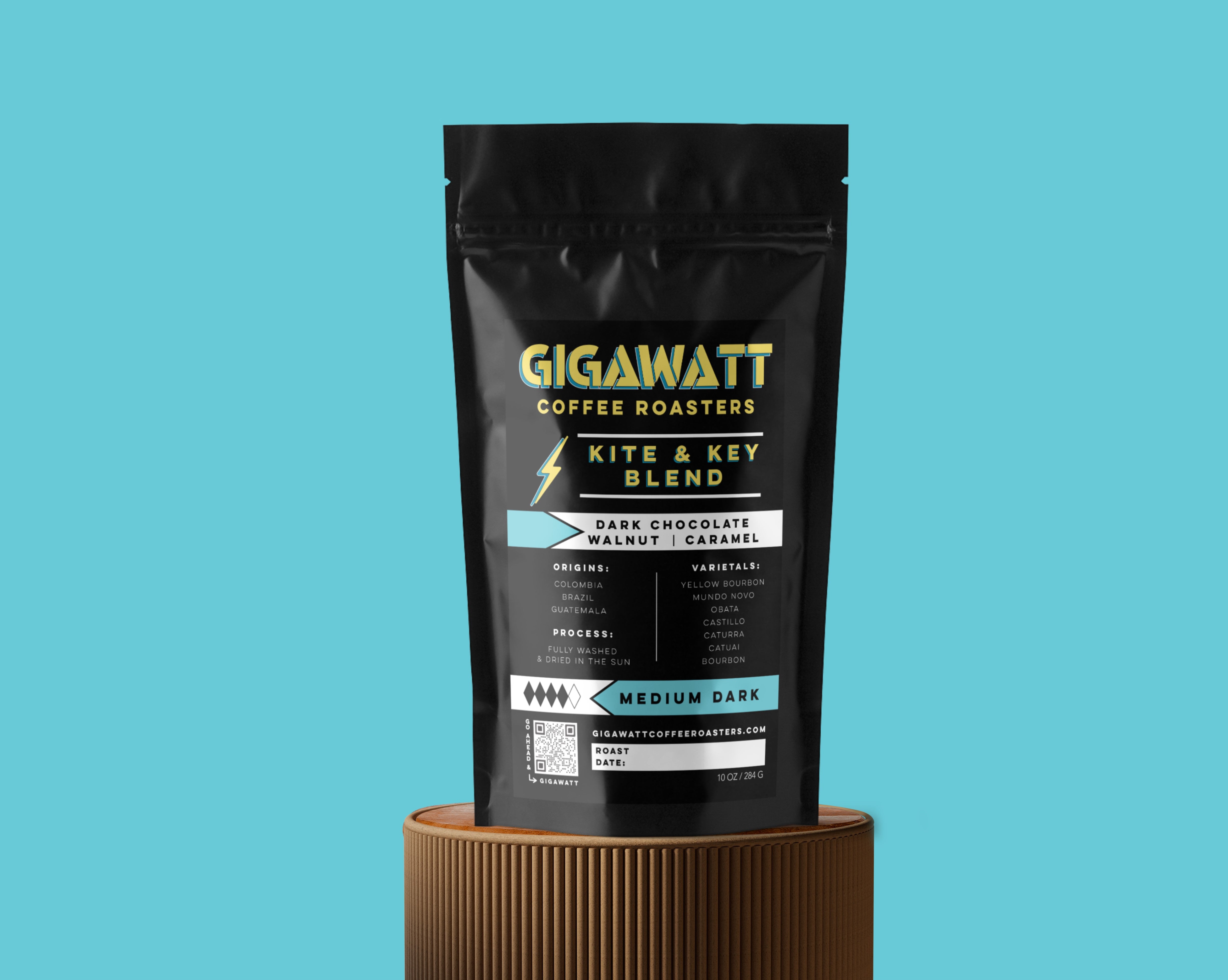 Gigawatt Coffee Bag of Kite and Key Blend sitting on a round brown pedestal with a light blue background.