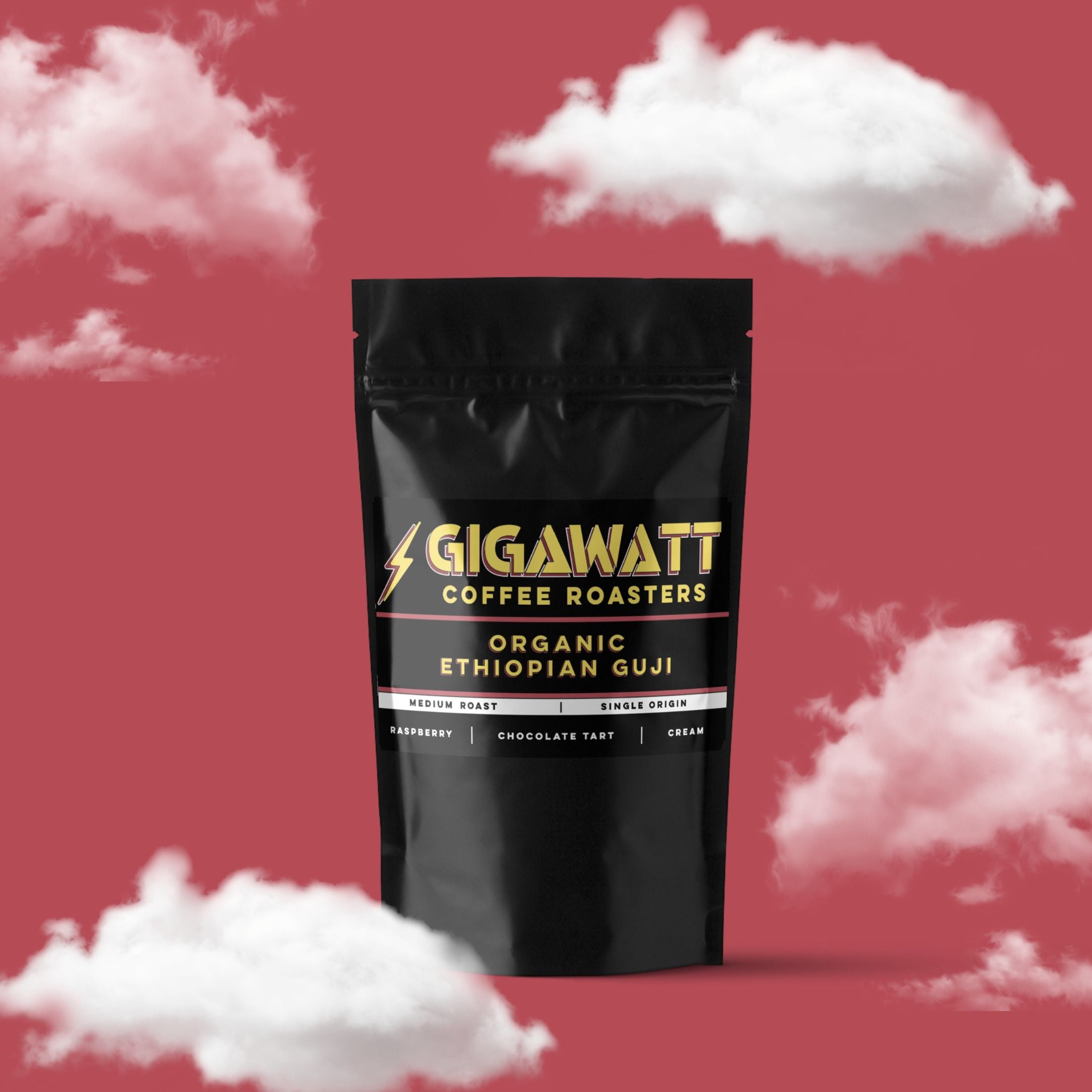 Gigawatt Coffee Organic Ethiopian Guji Coffee, medium roast single origin with raspberry, cream, and chocolate tart notes. 3 oz, set against a cloud-filled background.