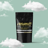 Gigawatt Coffee Sigri Estate Peaberry, 3 oz single origin Papua New Guinea coffee with medium roast and notes of blackcurrant, lemon pie, and sugarcane. Set against a cloud-filled background.