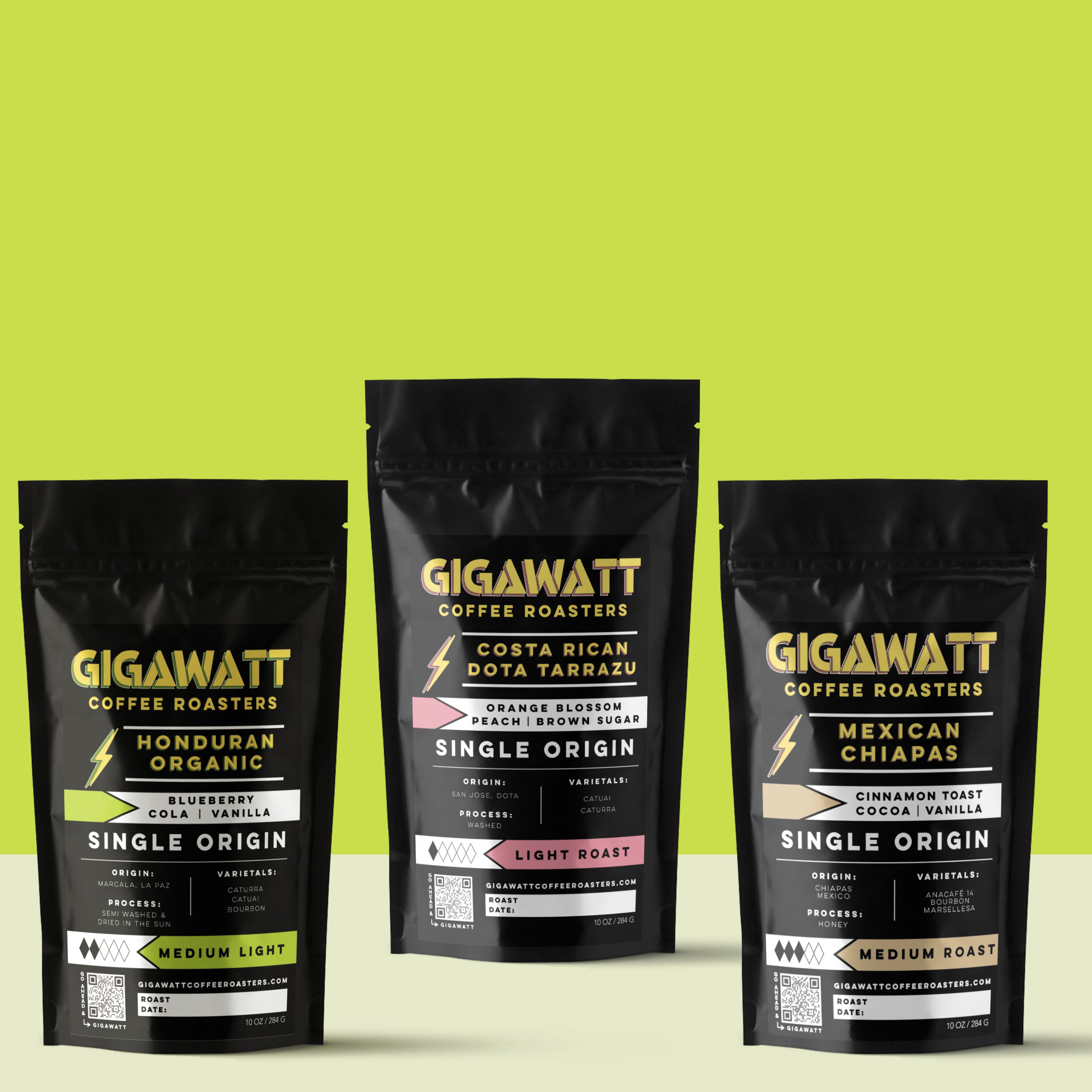 Gigawatt Coffee Single Origin Coffee Sampler, featuring bestselling Organic Honduran Coffee, Mexican Chiapas, and Costa Rican Tarrazu. A trio of single origin roasts with smooth, well-balanced flavor. 10 oz bags, displayed on a counter.